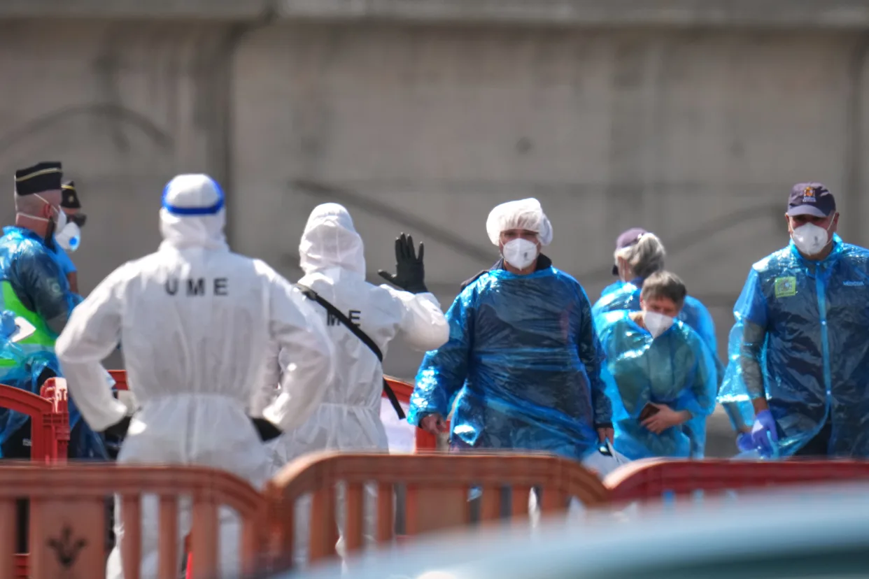 Passengers disembarking the MV Hondius in Tenerife escorted by Spanish military emergency personnel in full PPE